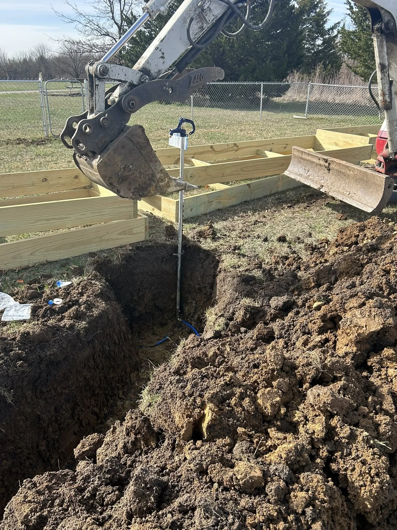 Excavator digging trench for new underground water line installation